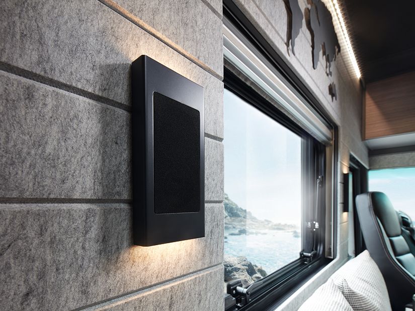 Clever sind die Surround-Lautsprecher in die schlanken Wandleuchten integriert. Der Akustikfilz bietet nicht nur eine angenehme Oberfläche, sondern dämpft auch den Ton im Wohnraum.