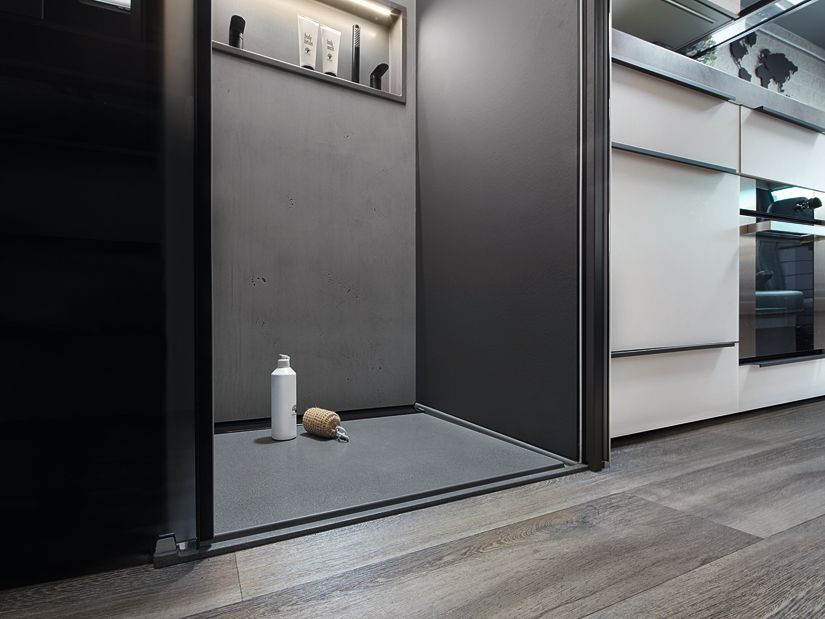 In Betonoptik, mit stufenlosem Zugang und dezenter Beleuchtung bietet die Dusche des Flair eine komfortable Wellness-Oase.